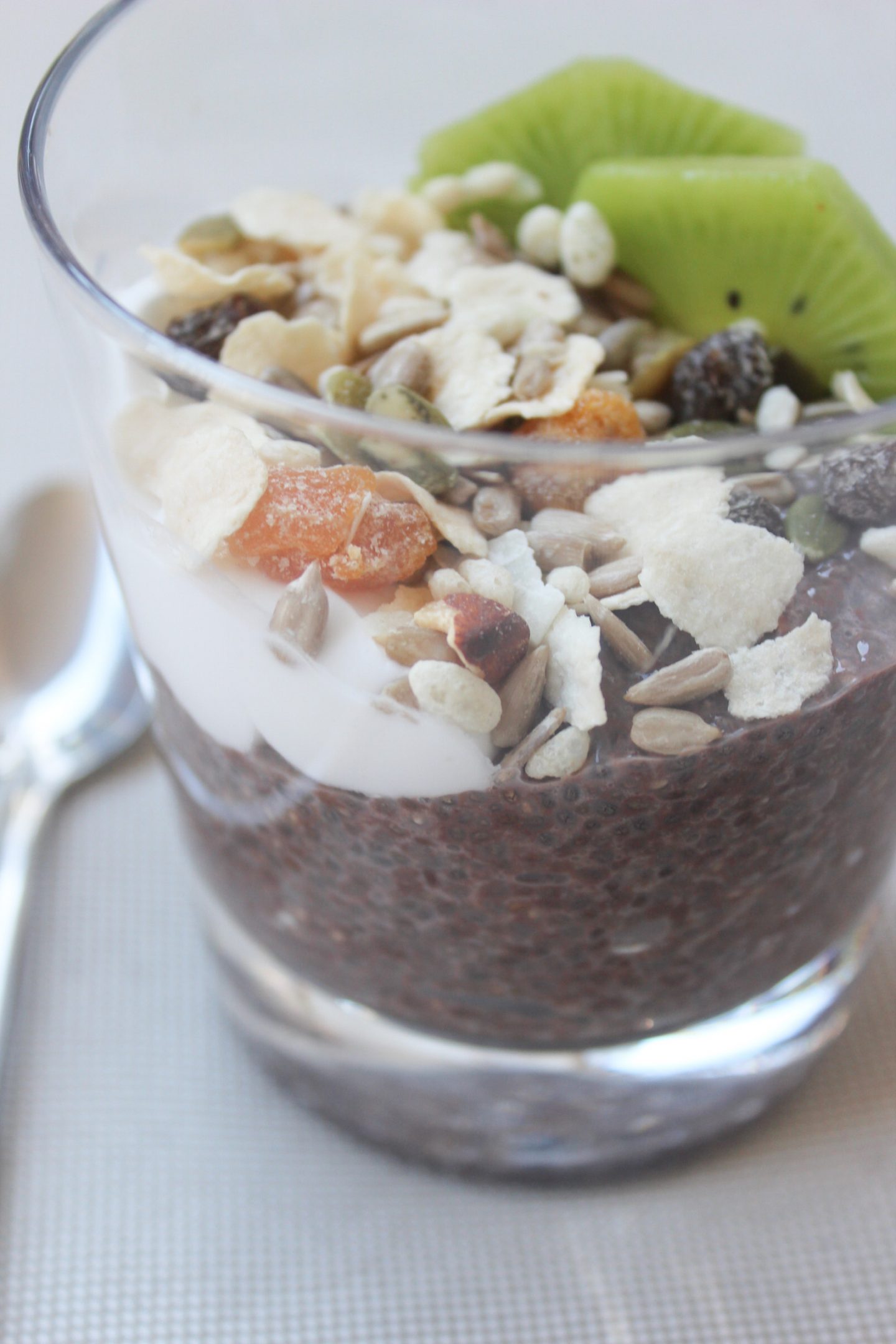 A photo of Chocolate Chia Seed Pudding topped with yoghurt, muesli and kiwi fruit