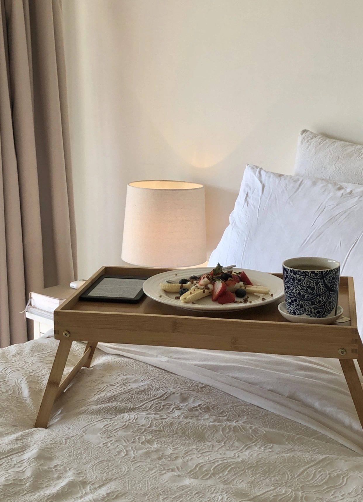 Breakfast in bed, featuring a healthy banana split recipe, tea and a kindle.